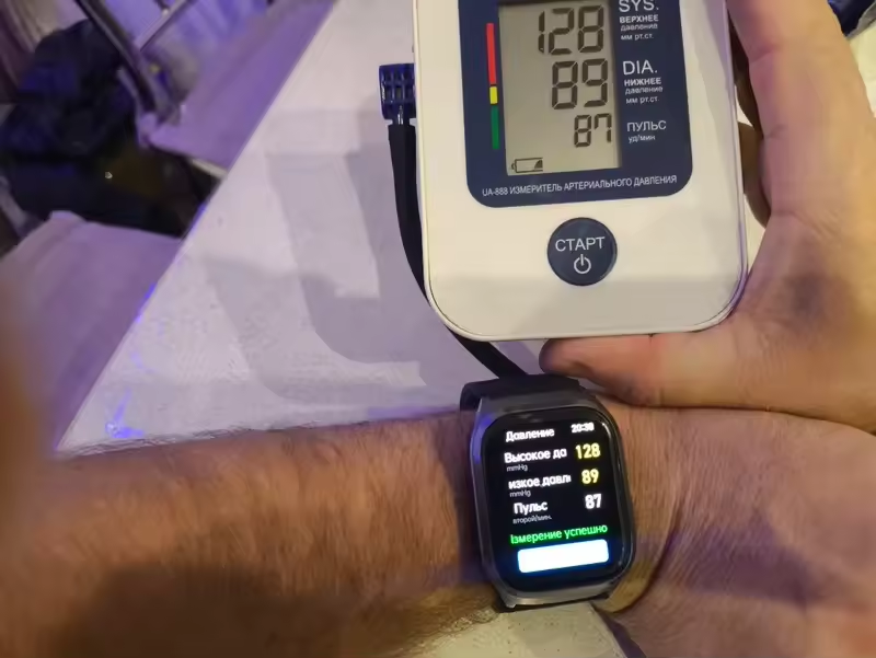 Buyer photo of the smartwatch worn on a wrist beside a home monitor